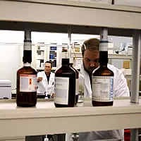 Panoramica di laboratorio di tossicologia con operatori al lavoro e flaconi di reattvi